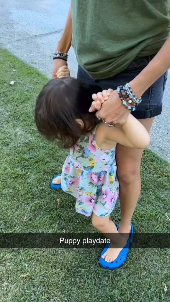 toddler standing on woman's feet